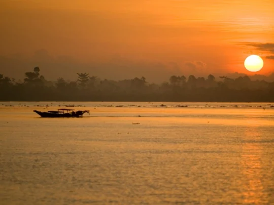 Mekong Smile Bassac Cruise Can Tho Cai Be Mekong River sunset with small boat silhouette