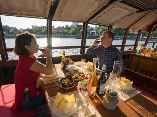 Guests enjoying dinner on Bassac Cruise at sunset on the Hau River, Can Tho