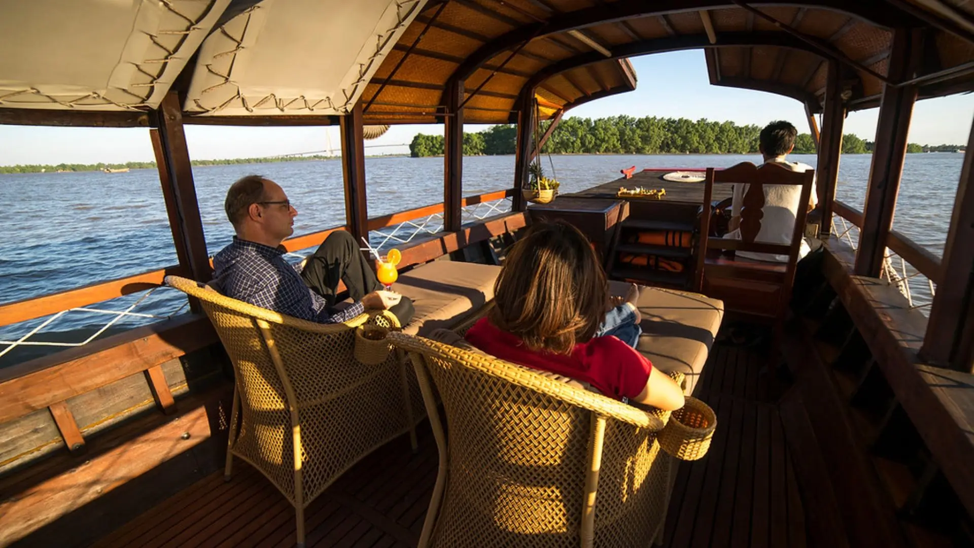 Guests relaxing on Bassac Cruise while watching sunset on the Hau River, Can Tho