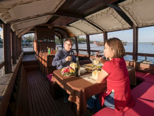 Dinner table on Bassac Cruise with river views in Can Tho, Mekong Delta