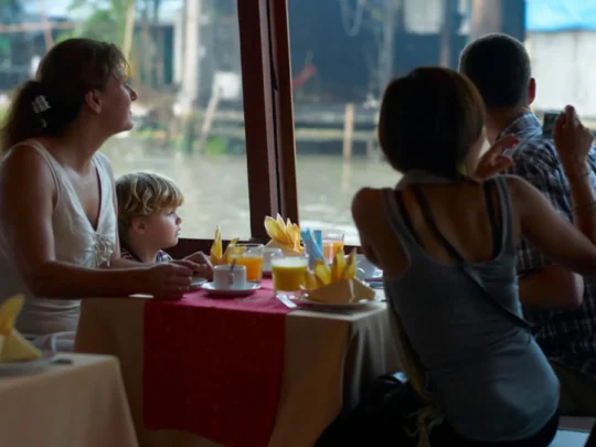 Family enjoying dinner on Bassac Cruise overlooking the Hau River in Can Tho