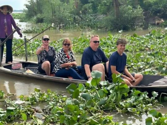 A group of tourists on a motorboat guided by a local in Cai Be