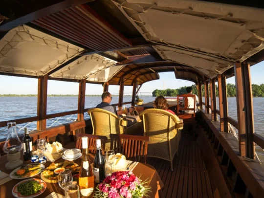 Interior of Bassac Cruise with river views during sunset in Can Tho