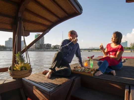 Guests relaxing on Bassac Cruise during sunset on the Hau River in Can Tho