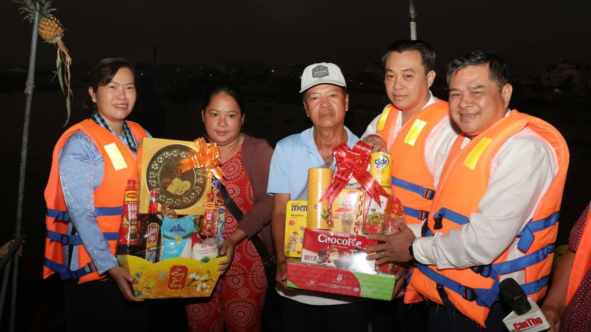 Mekong Smile volunteers distributing Tet gifts at Cai Rang Floating Market in Can Tho at night
