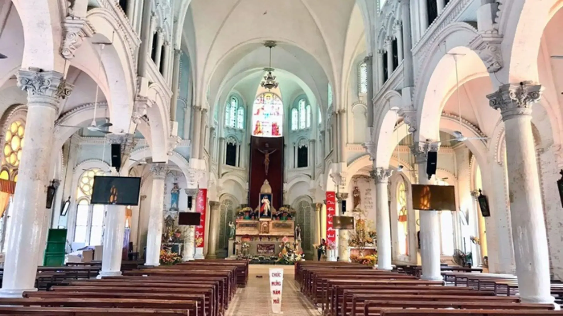 Interior of Cai Be Church in Cai Be, Tien Giang, Vietnam with high ceilings and wooden pews