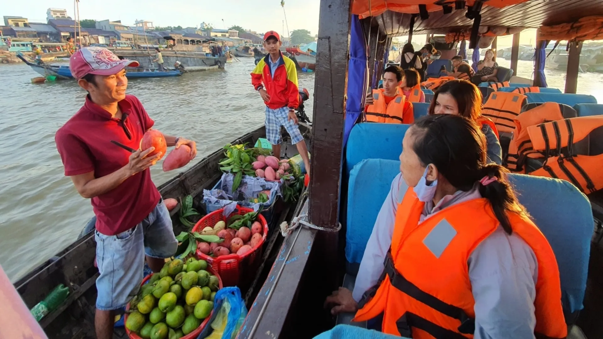 Mekong Smile Cai Be Floating Market local vendors trading goods with tourists on boats