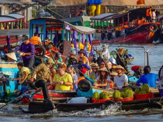Busy trading boats loaded with fruits at Cai Rang Floating Market in the Mekong Delta
