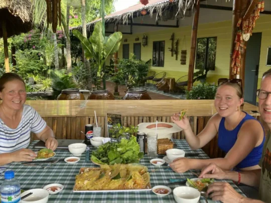 Tourists having lunch at a local home in the Mekong Delta during a Cai Rang Floating Market tour