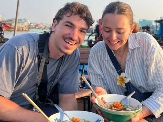 Tourists enjoying local food at Cai Rang Floating Market in Can Tho