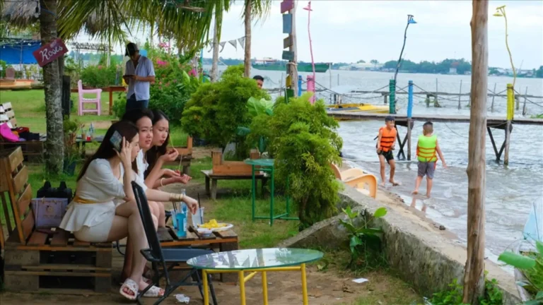 Tourists relaxing with drinks by the beach