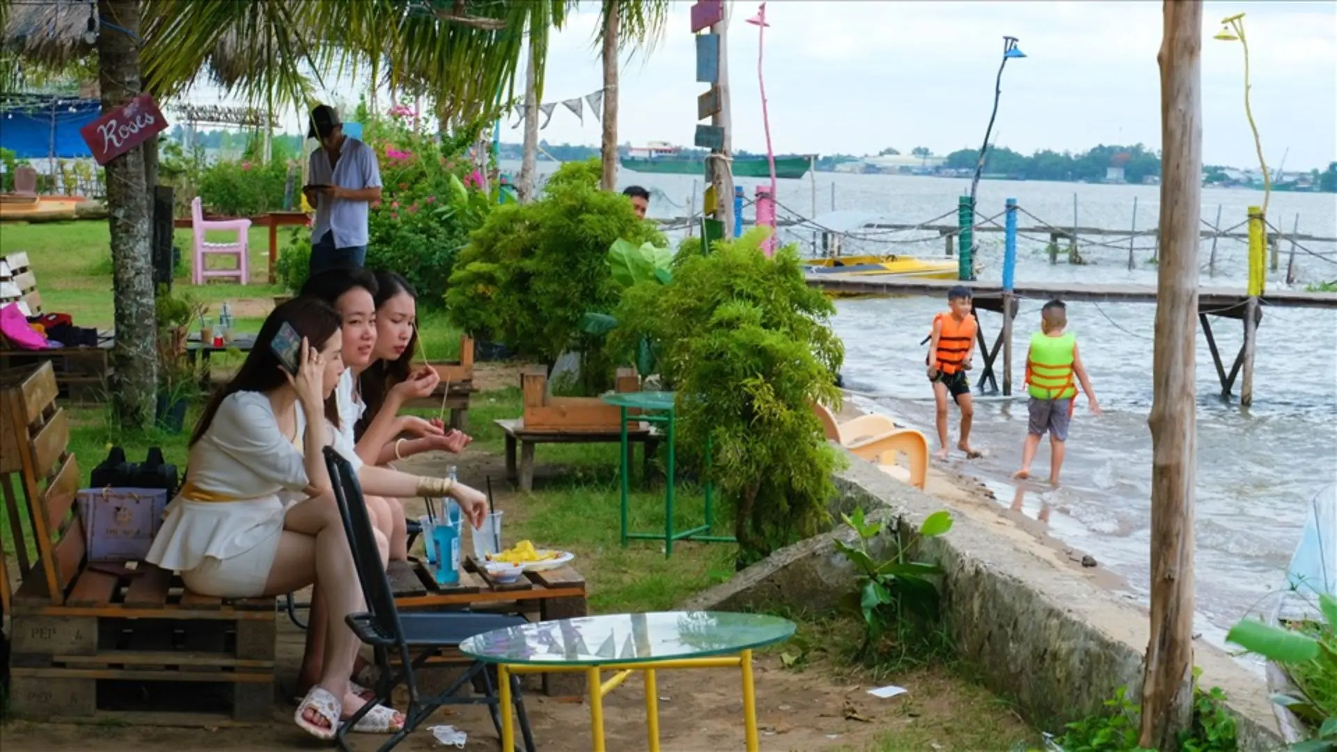Tourists relaxing with drinks by the beach