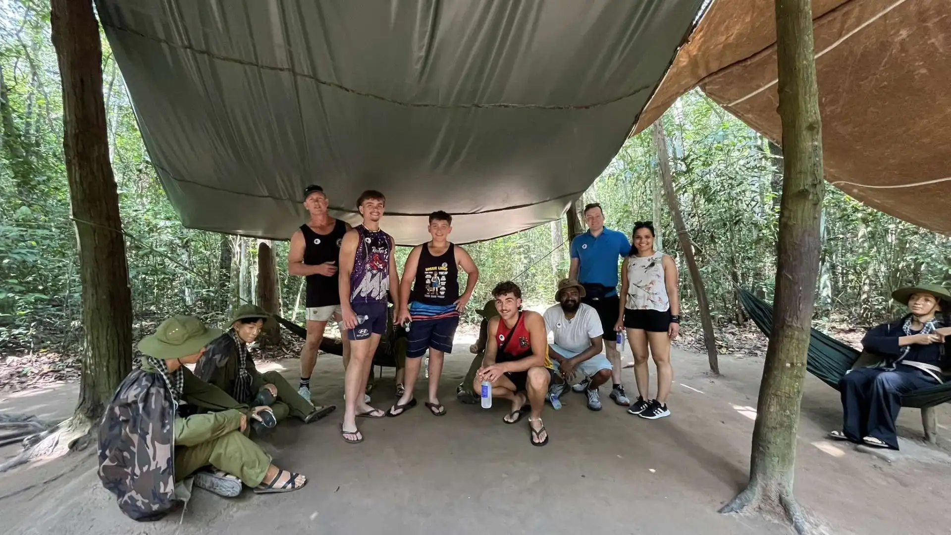 Tourists viewing a display or life-size model of wartime life in Cu Chi Tunnels Tour