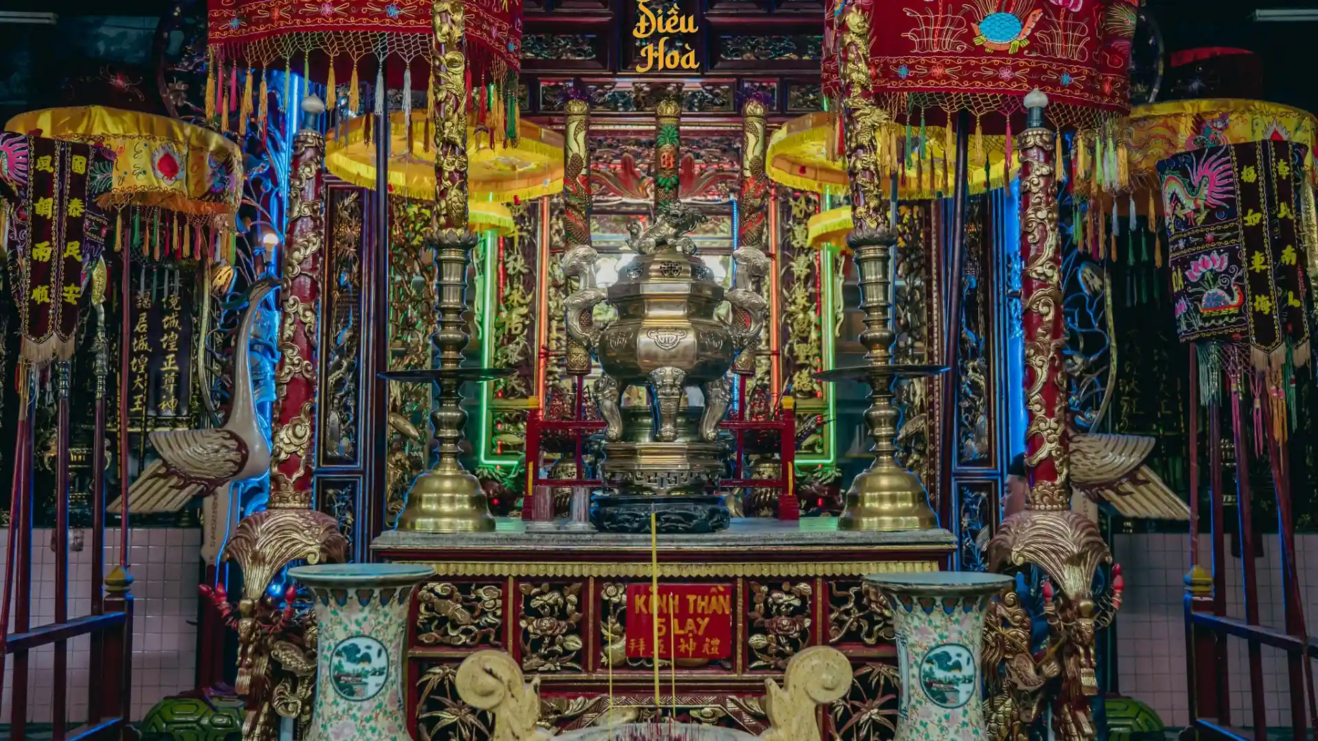 Ornate central altar and incense burners at Dieu Hoa Temple