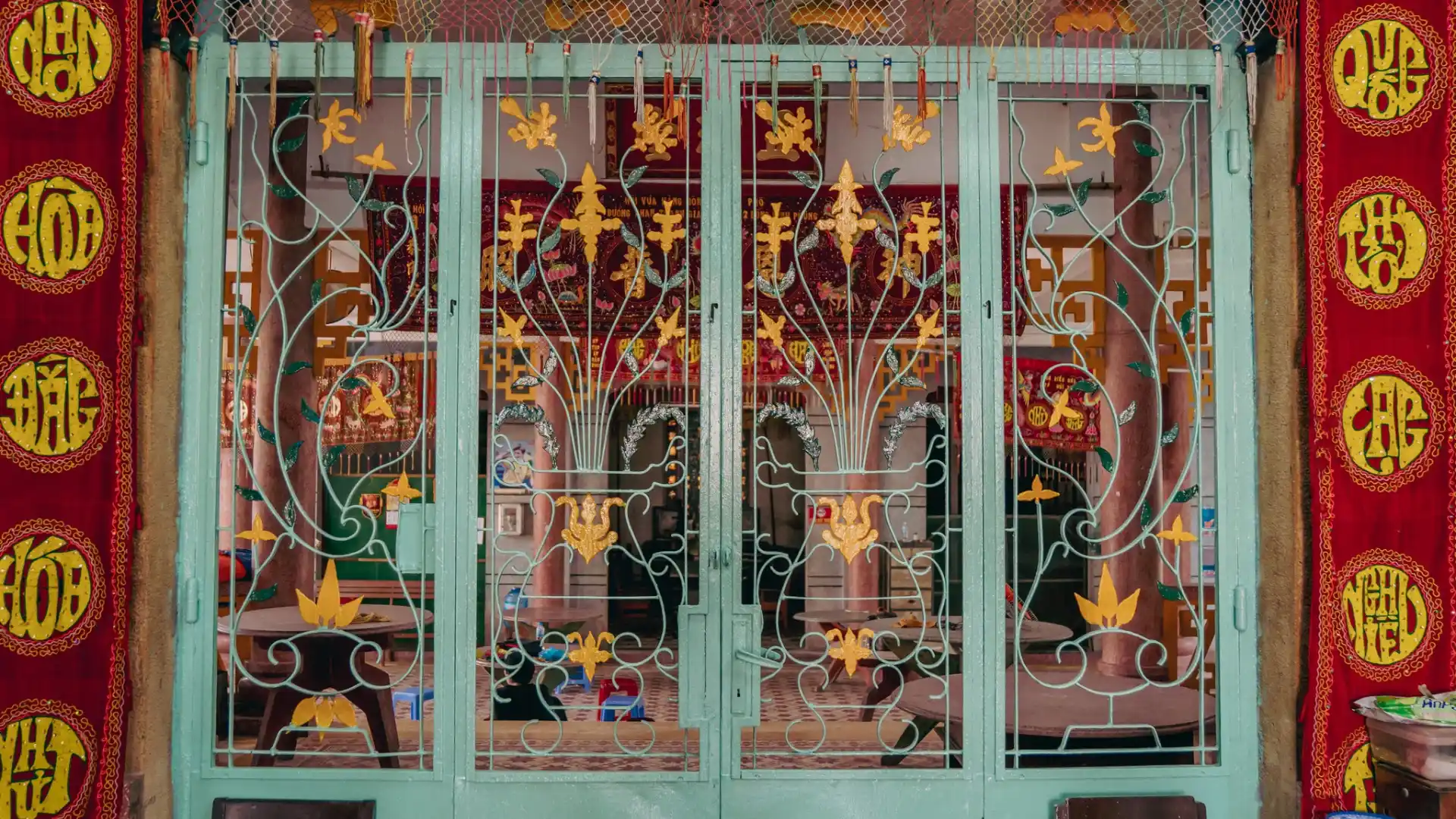 Decorative iron gates and red banners of Dieu Hoa Temple