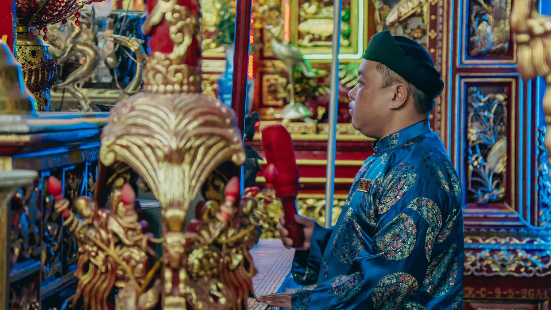 A man in traditional attire performing a ritual at Dieu Hoa Temple
