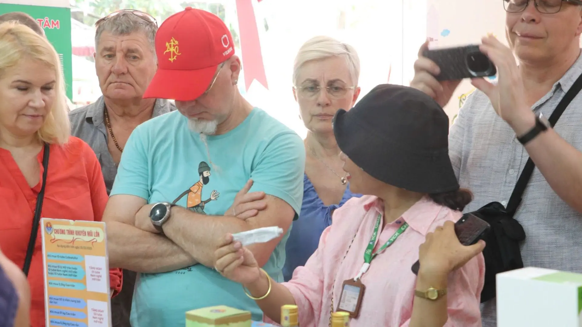 Tour guide explaining traditional medicinal products derived from snakes to tourists at Dong Tam Snake Farm in Tien Giang