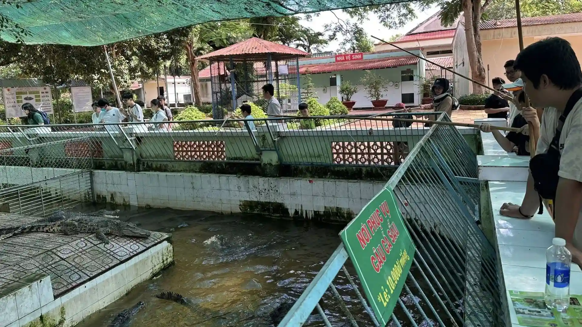 Visitors observing snake ponds and enclosures at Dong Tam Snake Farm in Tien Giang, Vietnam