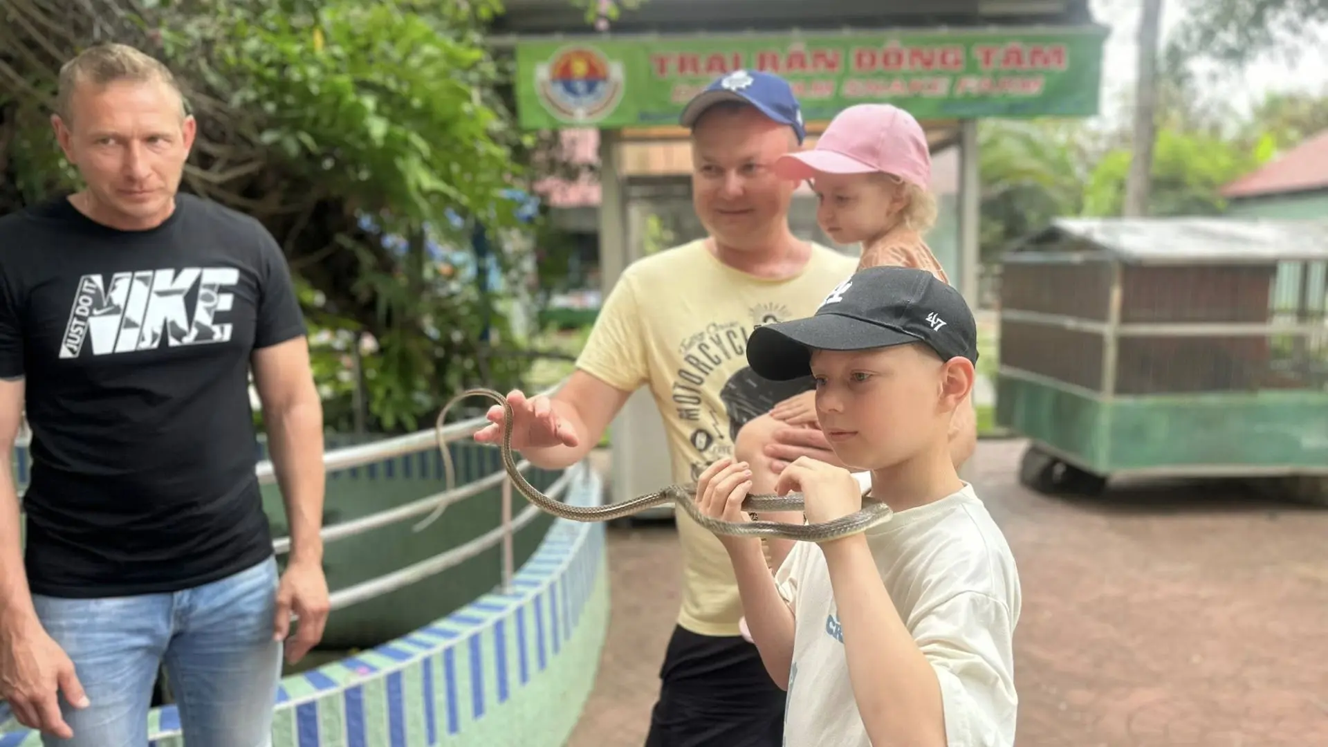 Tourists walking along the pathways near snake enclosures at Dong Tam Snake Farm in Tien Giang