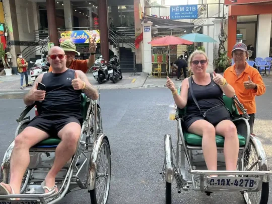 Tourists riding cyclos during a Ho Chi Minh Cycle Tour in Ho Chi Minh City