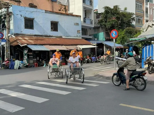 Cyclo crossing a local street on Ho Chi Minh Cyclo Tour in Ho Chi Minh City