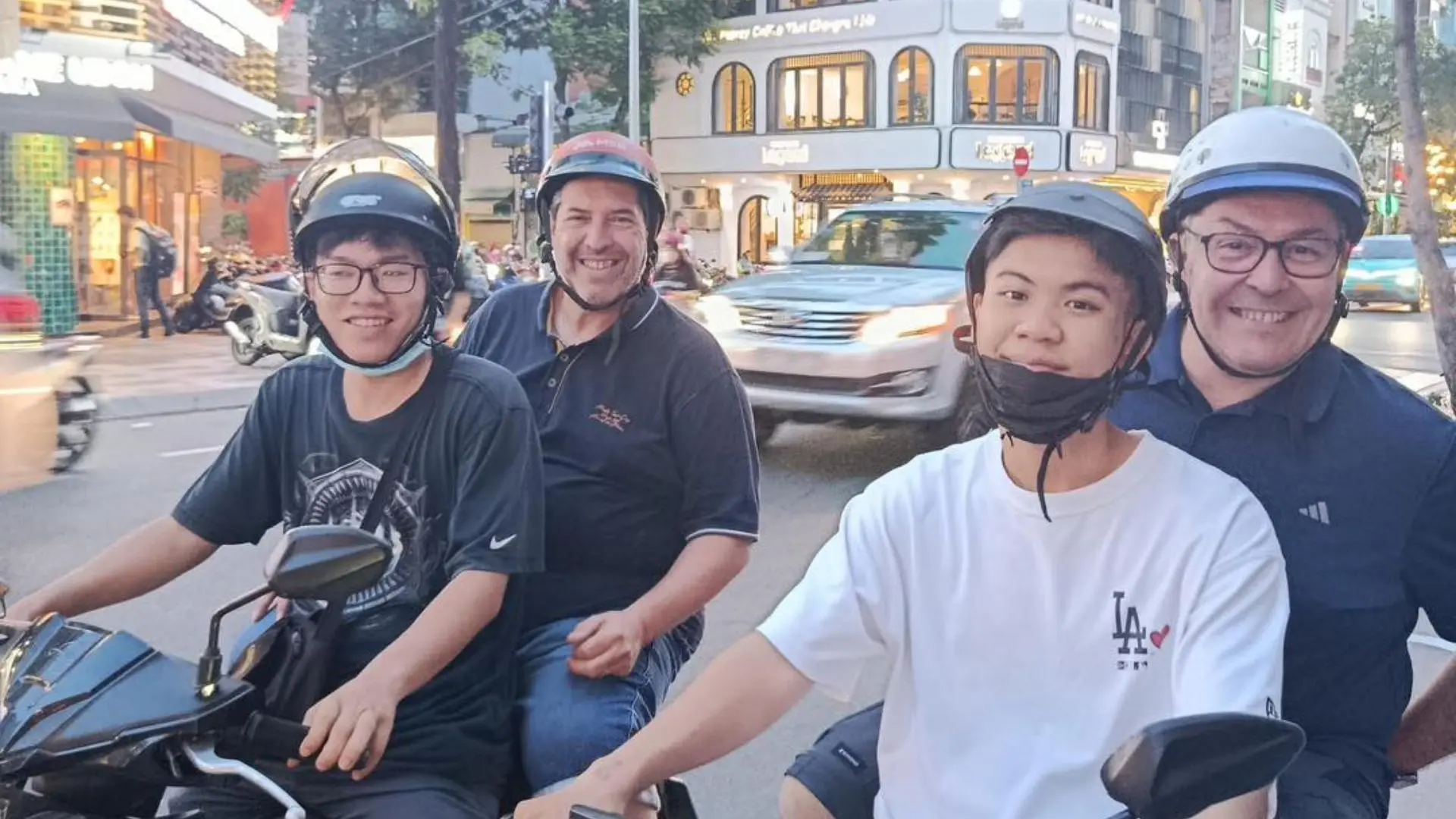 Group of travelers enjoying a Ho Chi Minh motorbike tour through busy city streets
