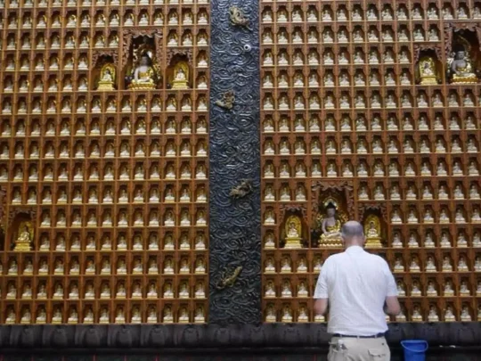Visitor praying at Ten Thousand Buddha Pagoda on Ho Chi Minh motorbike tour