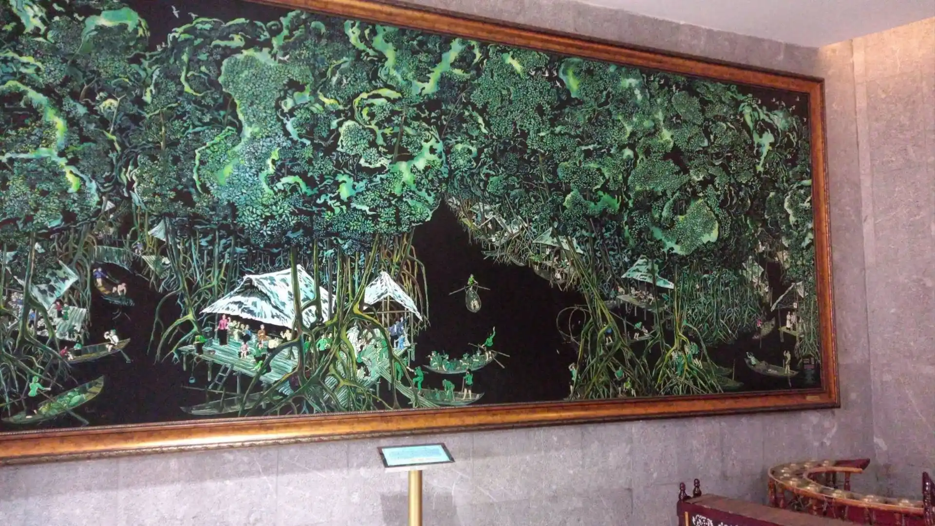 Large framed artwork displayed against a green wall at Hung King Temple Can Tho