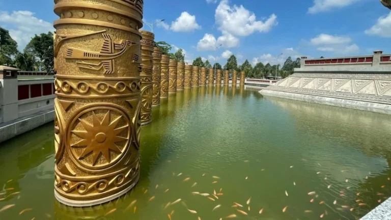 Row of decorative pillars reflected along a calm river at Hung King Temple Can Tho