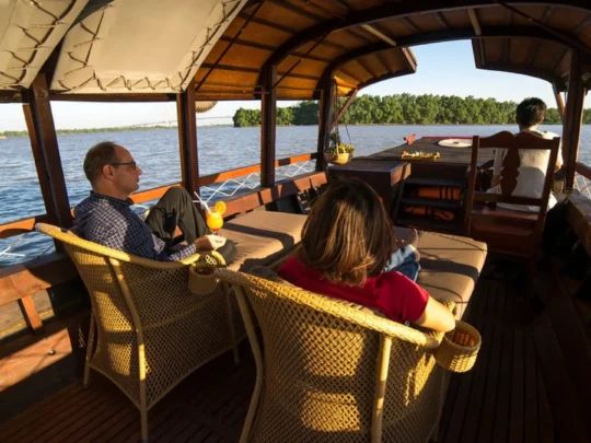 Guests relaxing on the open deck of Bassac Cruise during a Mekong Delta cruise in Can Tho, Vietnam
