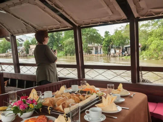Breakfast table by the river onboard Bassac Cruise during a Mekong Delta cruise in Can Tho, Vietnam