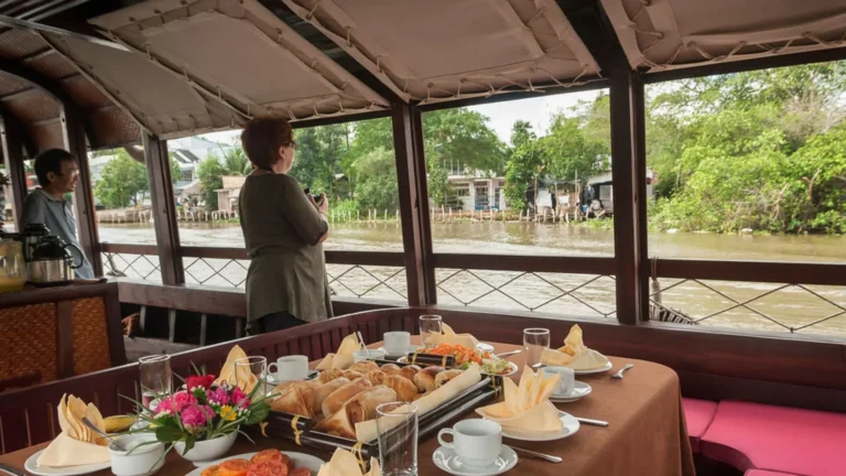 Breakfast table by the river onboard Bassac Cruise during a Mekong Delta cruise in Can Tho, Vietnam