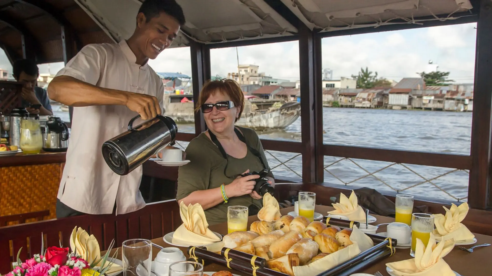 Crew serving breakfast to guests onboard Bassac Cruise on a luxury Mekong Delta cruise in Can Tho