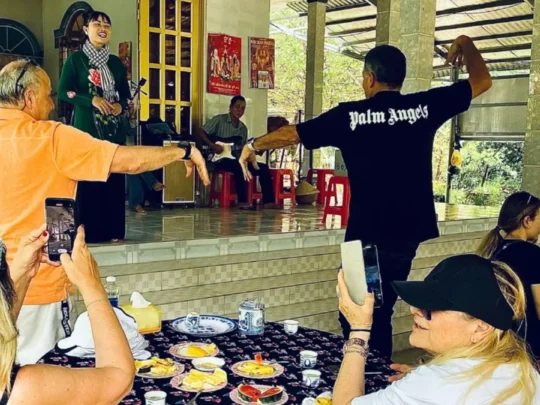 Tourists listening to a live performance of Southern Vietnamese folk music in Mekong Delta Tour Cai Be