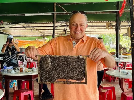 Guests visiting a small bee farm enclosure to see honey production