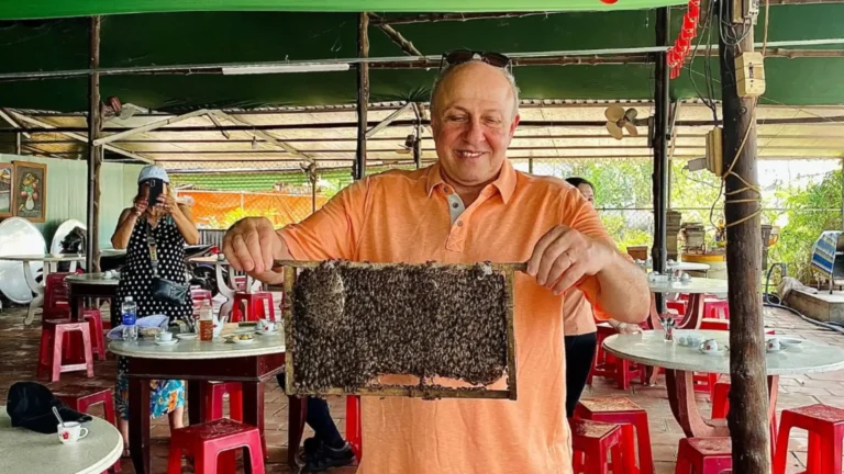 Guests visiting a small bee farm enclosure to see honey production