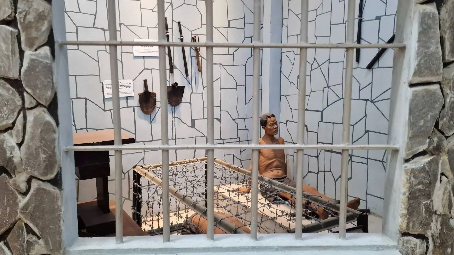 Prison cell replica at Military Zone 9 Museum in Can Tho illustrating wartime captivity.