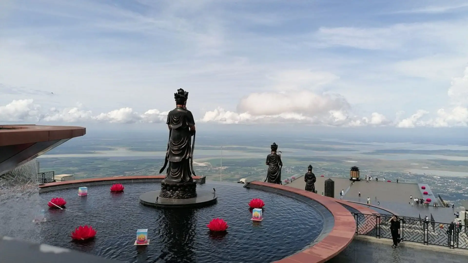 Buddha statue with prayer offerings on Ba Den Mountain summit, Tay Ninh