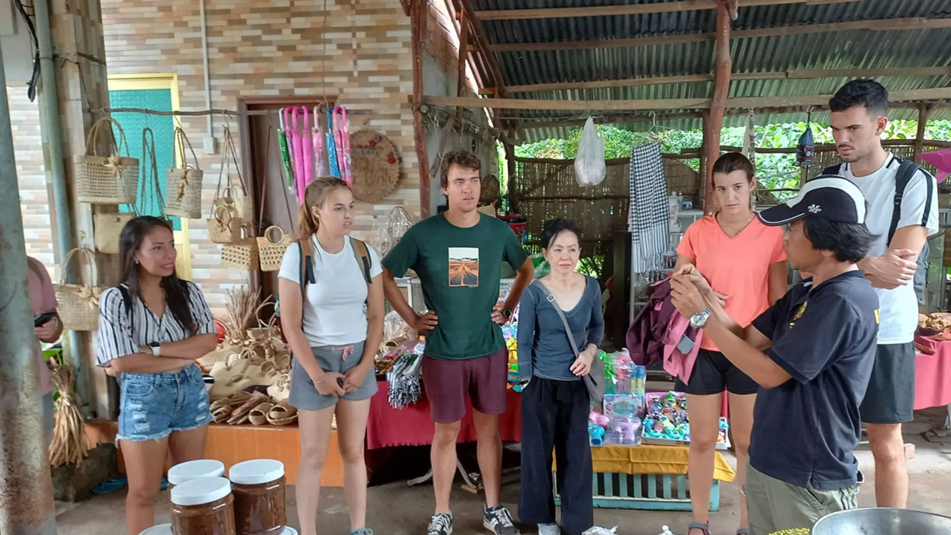 A local guide explaining traditional production methods to a group of international tourists on Tan Phong Islet