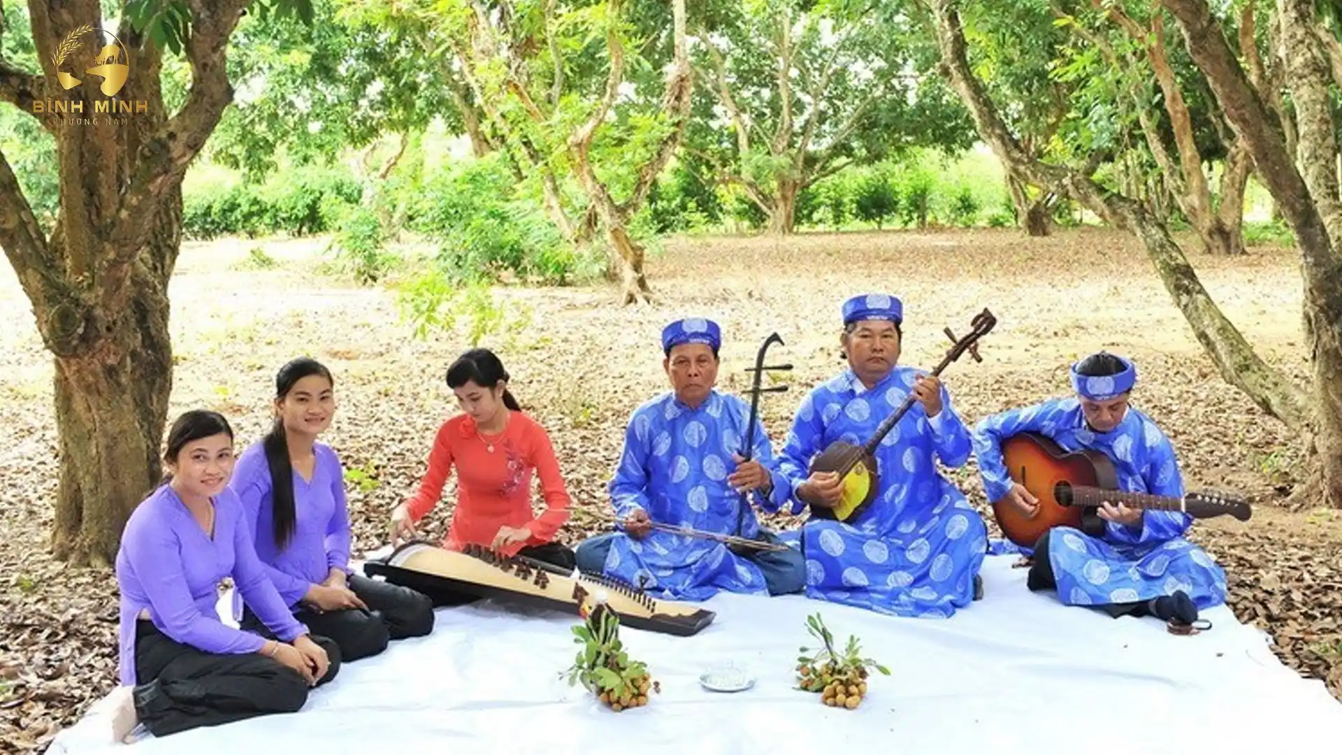 Local musicians and singers in traditional blue and purple "ao dai" performing folk music in a garden on Tan Phong Islet