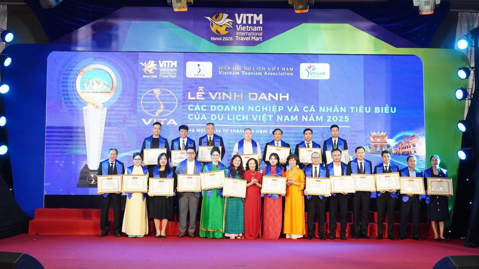 Group photo of tourism award winners, including Mekong Smile representatives, on stage at VITM Hanoi 2026