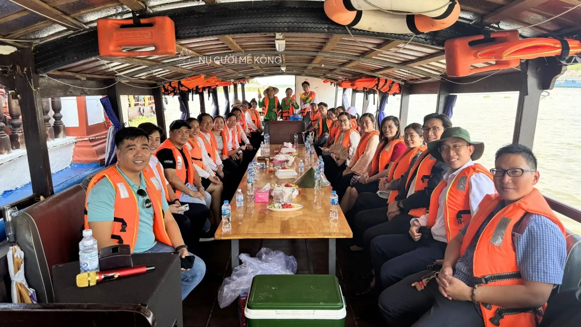 Mekong Smile team and visitors wearing life jackets on a boat tour during Tong Phong Festival in Can Tho