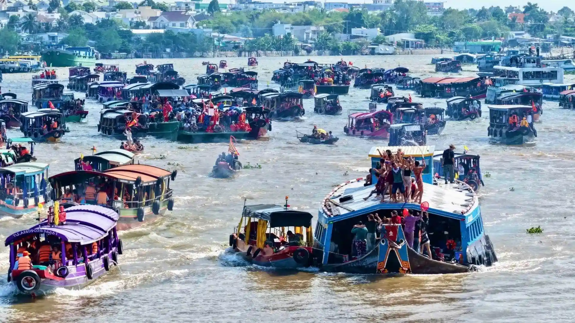 Colorful boats and crowds celebrating Tong Phong Festival on the river in Can Tho city
