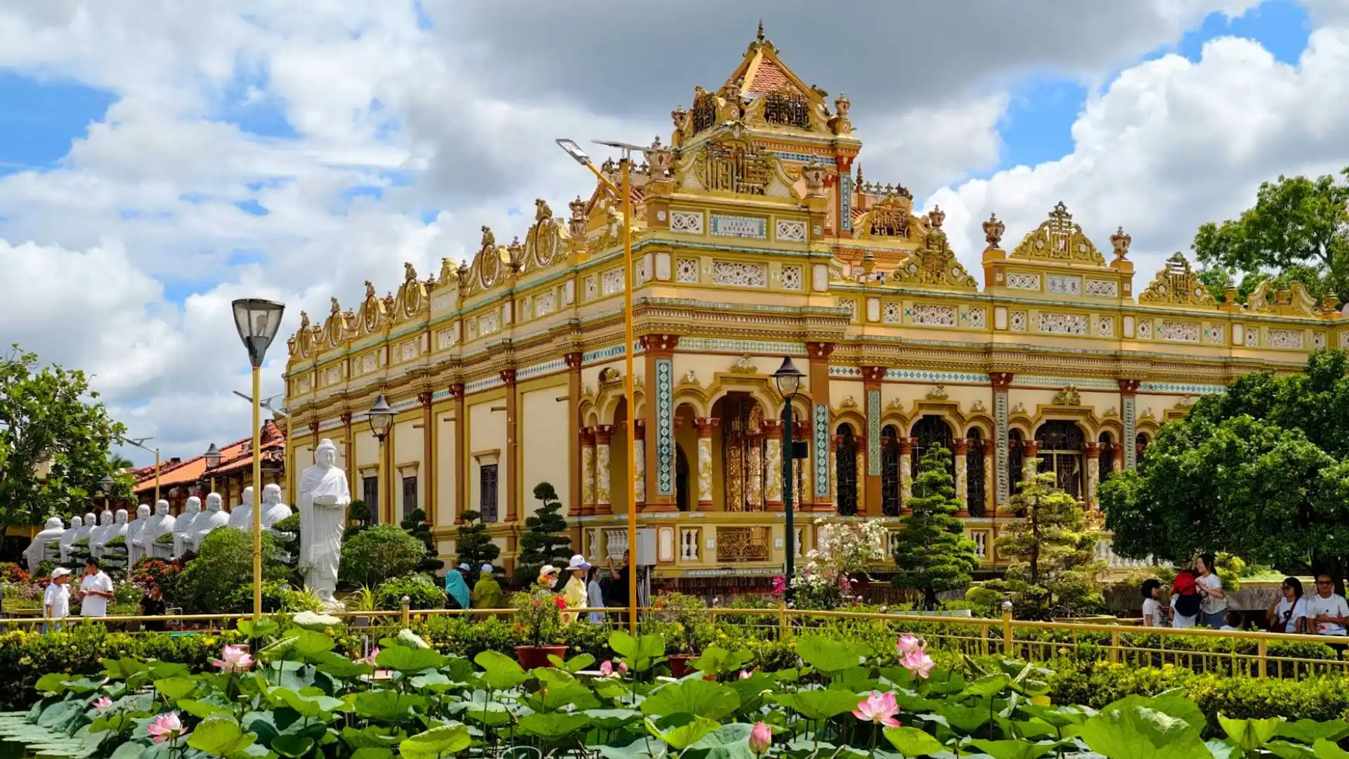 Front view of Vinh Trang Pagoda with lotus pond in My Tho, Tien Giang
