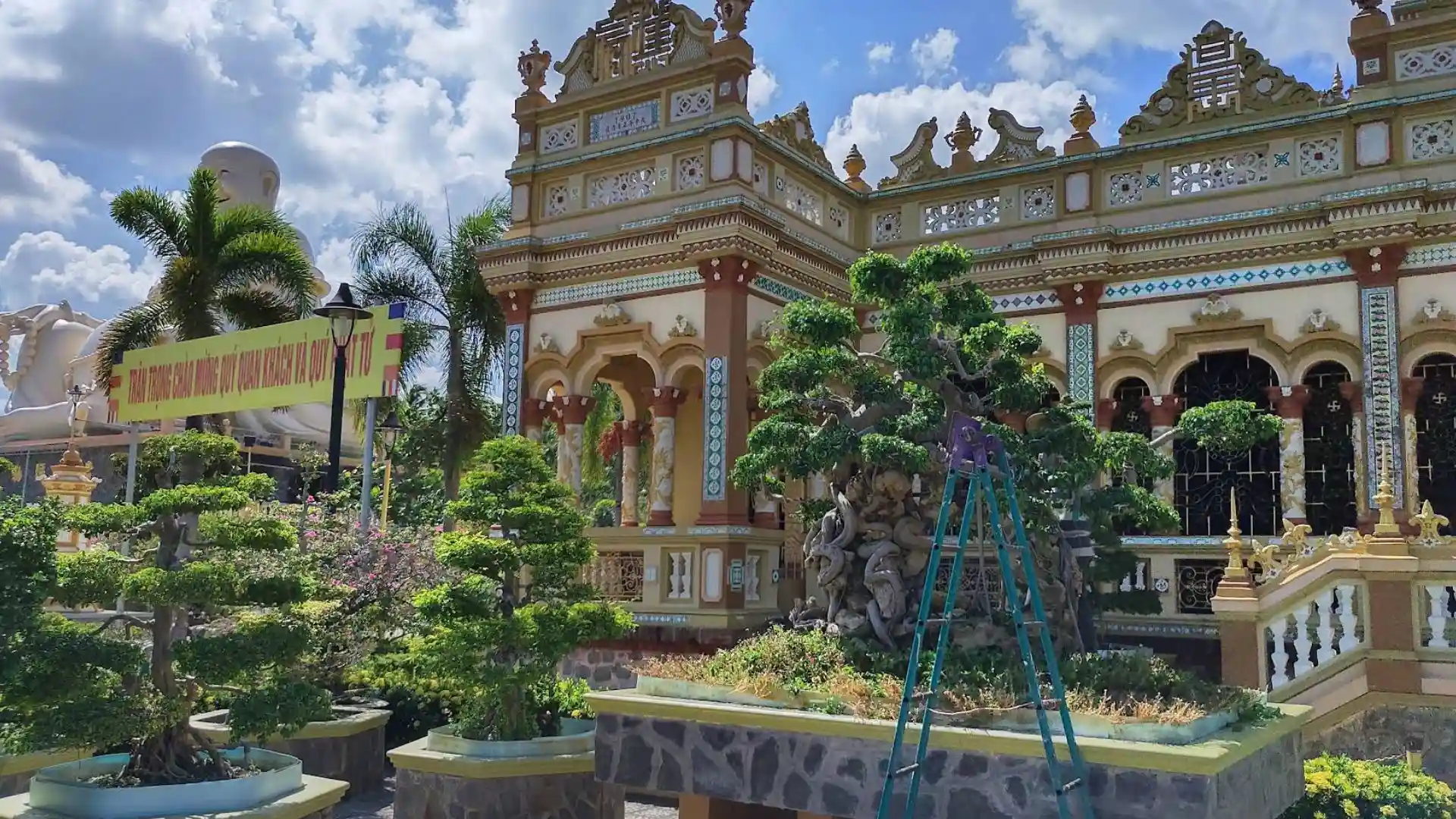 Temple garden and surrounding architecture at Vinh Trang Pagoda in Tien Giang