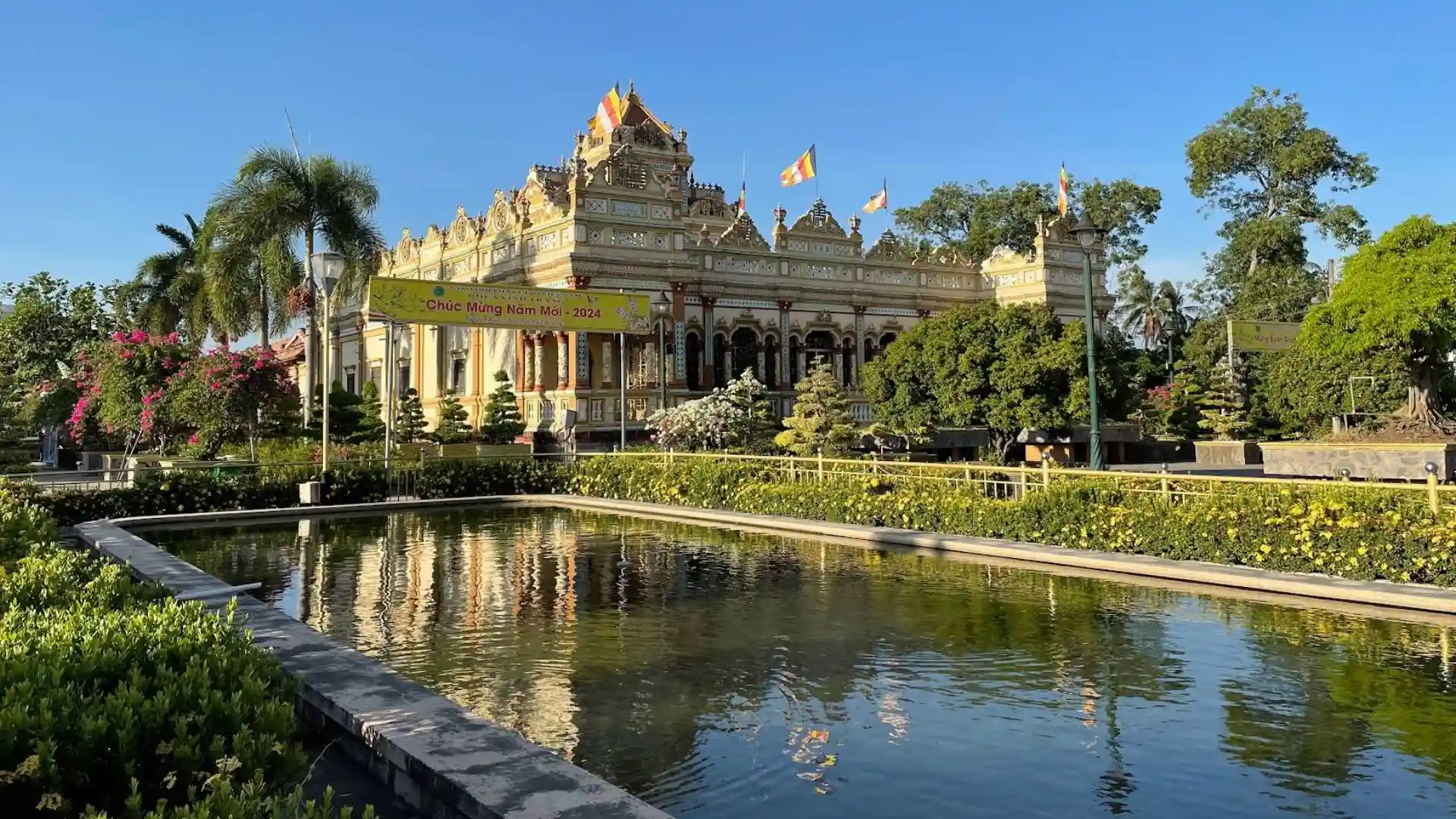 Reflection of Vinh Trang Pagoda architecture in the garden pond, Tien Giang
