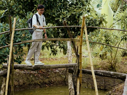 Crossing the traditional monkey bridge over small canals in the Mekong Delta