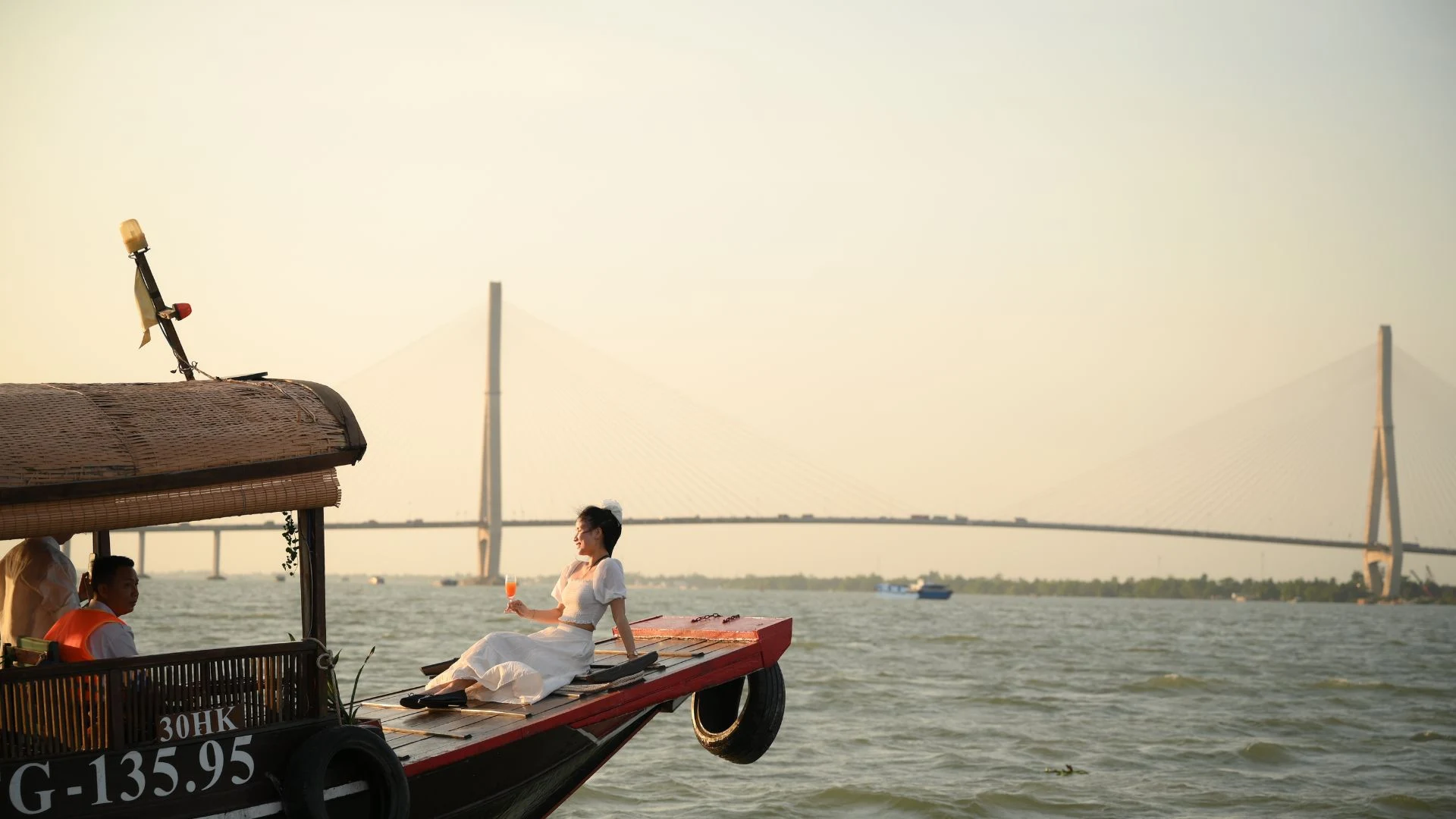 Tourists taking photos with Can Tho Bridge at sunset – Can Tho Sunset Tour with Mekong Smile