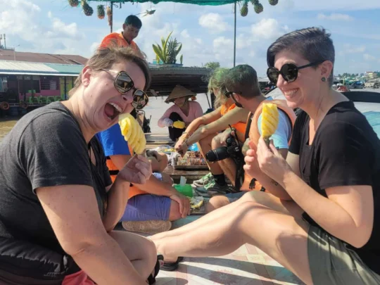 Tasting fresh pineapples bought directly from a vendor boat at Cai Rang Floating Market