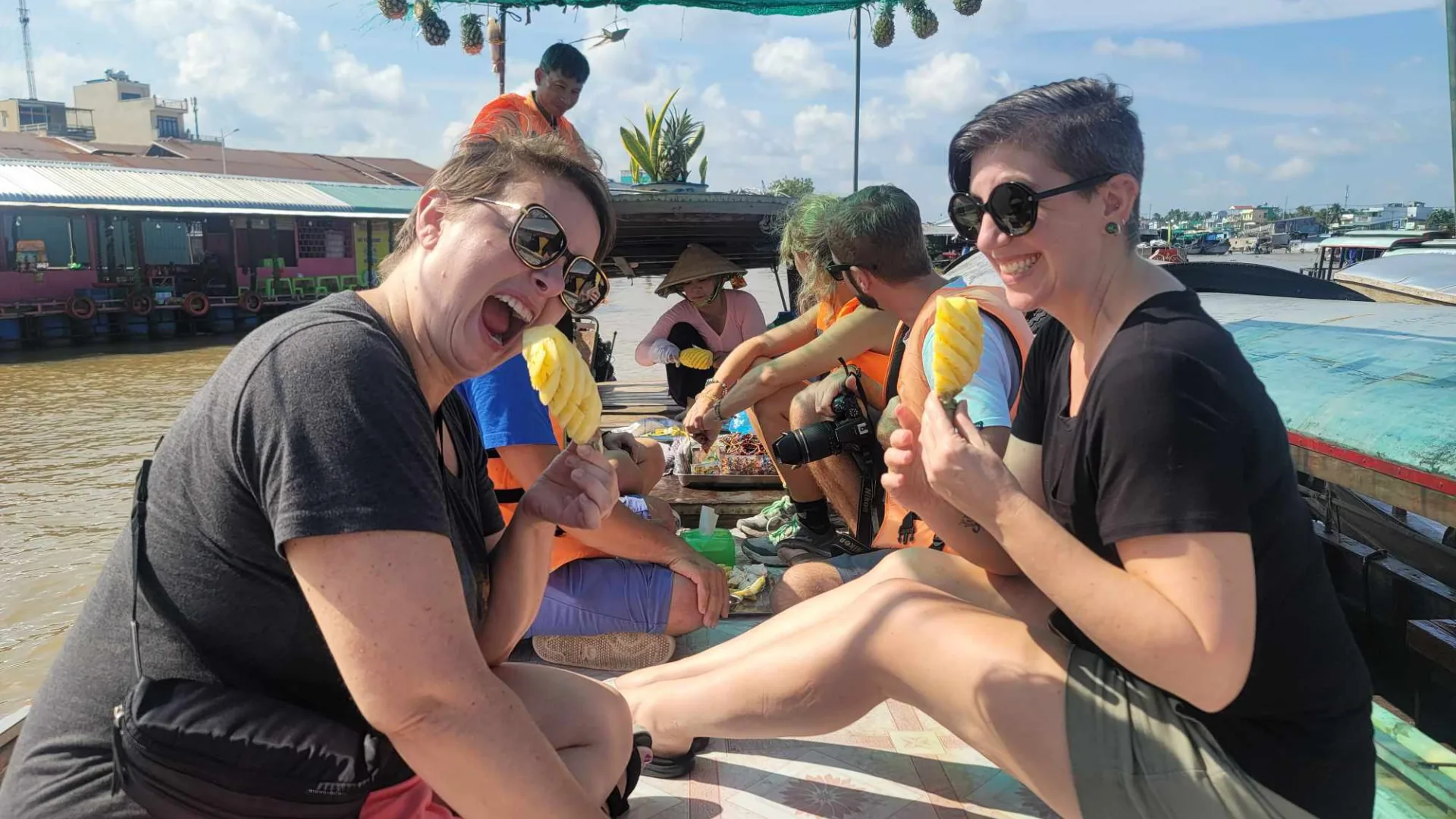 Tasting fresh pineapples bought directly from a vendor boat at Cai Rang Floating Market